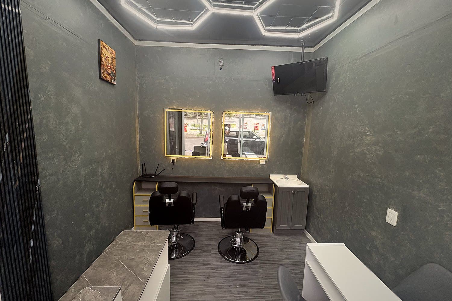 Interior de TRIBU STUDIO con estaciones de barbería y nail studio